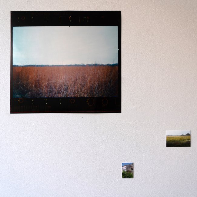 Installation view of one large and three small landscape photographs arranged geometrically