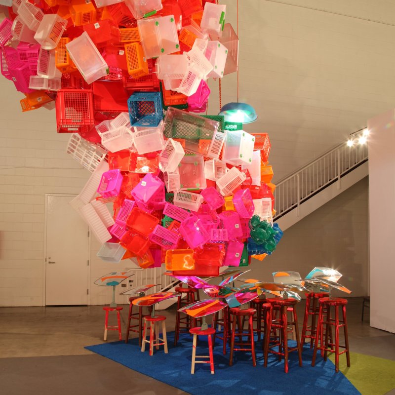 Image: Jessica Stockholder, “Once Upon a Time,” 2014, carpet, wooden stools, driveway mirrors, oil paint, lamps, plastic containers, zip ties, cable, orange chain, installed at ExpoChicago