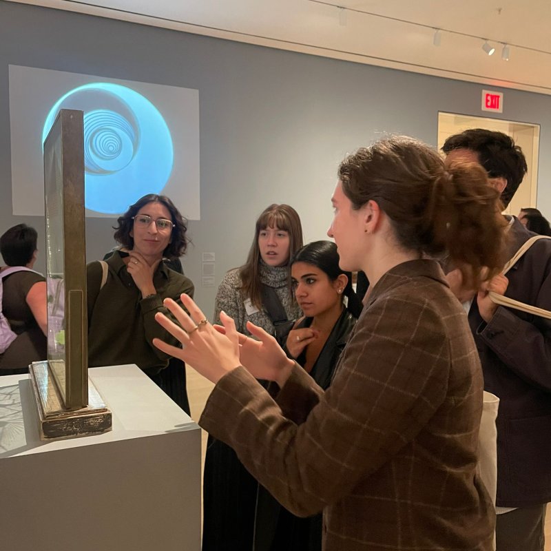 Woman showing object in museum